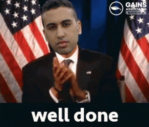 A Man In A Suit And Tie Is Applauding In Front Of An American Flag With The Words Well Done Below Him GIF