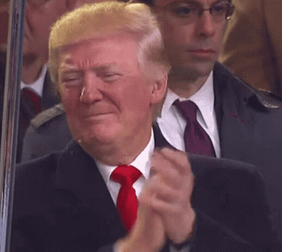 A Man In A Suit And Tie Is Applauding GIF