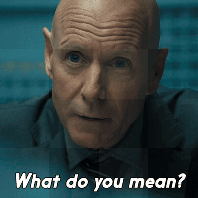 A Man In A Suit And Tie Is Asking What Do You Mean GIF