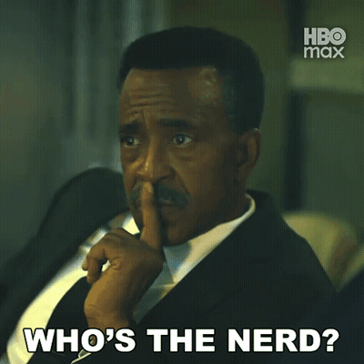 A Man In A Suit And Tie Is Asking " Who 'S The Nerd " GIF