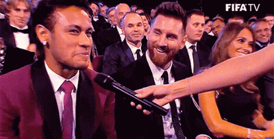 A Man In A Suit And Tie Is Being Interviewed By A Woman In A Crowd Of People . GIF