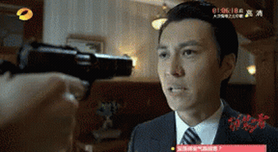 A Man In A Suit And Tie Is Being Shot With A Gun In A Room GIF