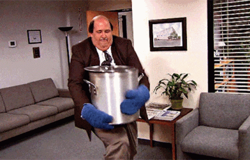 A Man In A Suit And Tie Is Carrying A Pot GIF