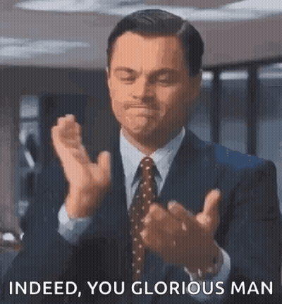 A Man In A Suit And Tie Is Clapping His Hands And Saying `` Indeed You Glorious Man '' . GIF