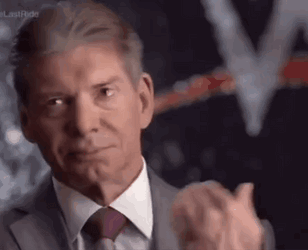 A Man In A Suit And Tie Is Clapping His Hands In A Blurry Photo . GIF