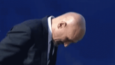 A Man In A Suit And Tie Is Clapping His Hands . GIF
