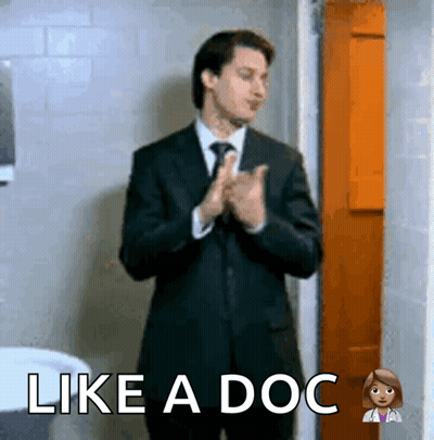 A Man In A Suit And Tie Is Clapping His Hands With The Words Like A Doc Above Him GIF