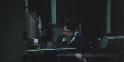 A Man In A Suit And Tie Is Covering His Ears With His Hands And The Word Argh Is Written Above Him GIF