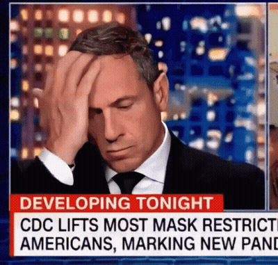 A Man In A Suit And Tie Is Covering His Face In Front Of A News Report That Says " Developing Tonight " GIF