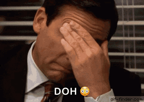 A Man In A Suit And Tie Is Covering His Face With His Hands And The Word Doh Is Above Him . GIF