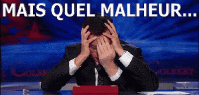 A Man In A Suit And Tie Is Covering His Face With His Hands And The Words Mais Quel Malheur Are Written Above Him GIF