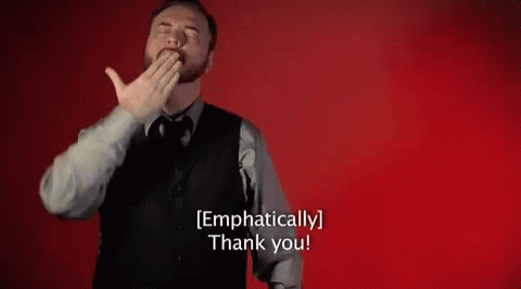 A Man In A Suit And Tie Is Covering His Mouth With His Hand And Says `` Emphatically Thank You '' . GIF