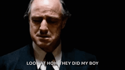 A Man In A Suit And Tie Is Crying In A Dark Room And Says `` Look At How They Did My Boy '' . GIF