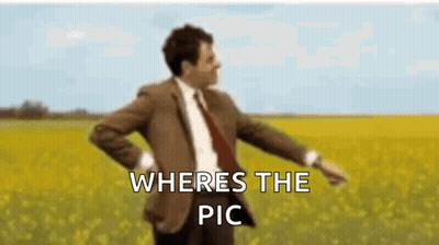 A Man In A Suit And Tie Is Dancing In A Field With The Words `` Where 'S The Pic '' Written Above Him . GIF