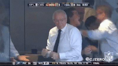 A Man In A Suit And Tie Is Dancing In Front Of A Cbs Nfl Broadcast GIF