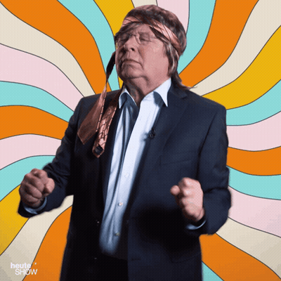 A Man In A Suit And Tie Is Dancing In Front Of A Colorful Background With The Words Heute Show On It GIF