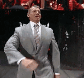A Man In A Suit And Tie Is Dancing In Front Of A Crowd GIF