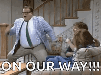 A Man In A Suit And Tie Is Dancing In Front Of A Group Of People . GIF