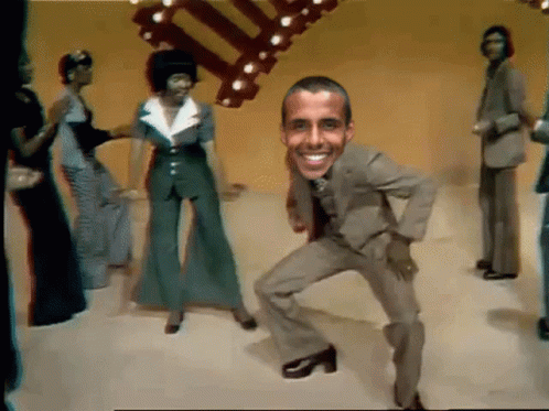 A Man In A Suit And Tie Is Dancing In Front Of A Group Of People GIF