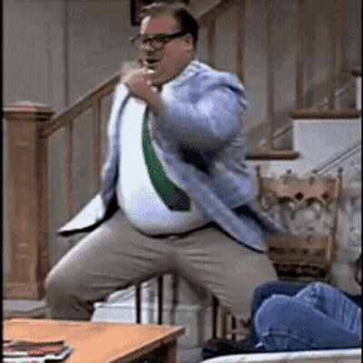 A Man In A Suit And Tie Is Dancing In Front Of Stairs GIF
