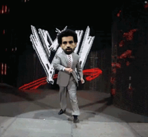 A Man In A Suit And Tie Is Dancing On A Stage In Front Of A W Logo GIF