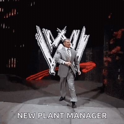 A Man In A Suit And Tie Is Dancing On A Stage With The Words `` New Plant Manager '' Written On It . GIF