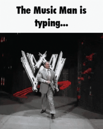 A Man In A Suit And Tie Is Dancing On A Stage With The Words " The Music Man Is Typing " GIF