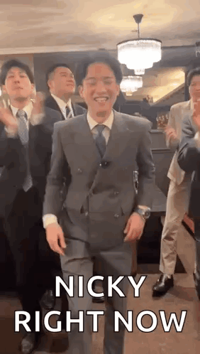A Man In A Suit And Tie Is Dancing With A Group Of Men . GIF