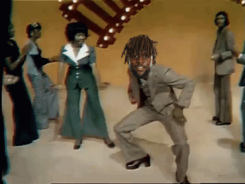 A Man In A Suit And Tie Is Dancing With A Group Of People GIF