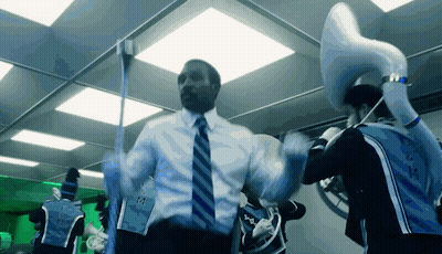 A Man In A Suit And Tie Is Dancing With A Man In A Blue Shirt That Says ' Miami ' On The Side GIF