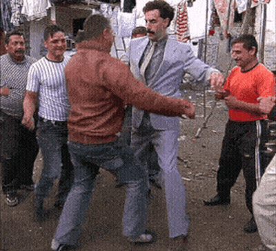 A Man In A Suit And Tie Is Dancing With Another Man GIF