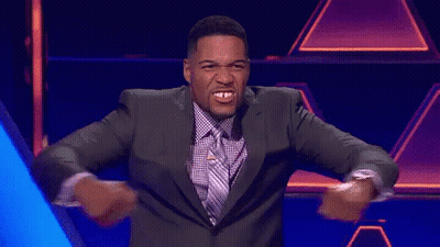 A Man In A Suit And Tie Is Dancing With His Arms Outstretched GIF