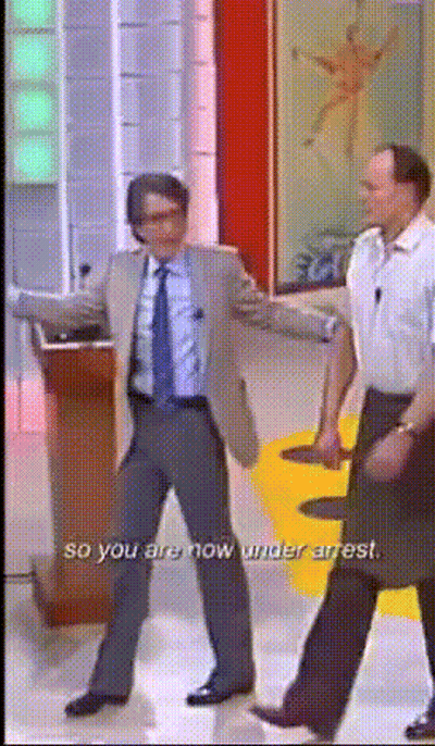 A Man In A Suit And Tie Is Dancing With The Words So You Are Now Under Arrest GIF