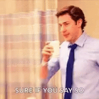A Man In A Suit And Tie Is Drinking A Cup Of Coffee . GIF