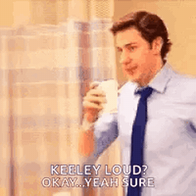 A Man In A Suit And Tie Is Drinking A Cup Of Coffee And Talking To Someone . GIF
