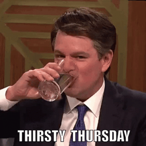 A Man In A Suit And Tie Is Drinking A Glass Of Water On A Thursday . GIF