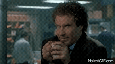 A Man In A Suit And Tie Is Drinking From A Cup GIF