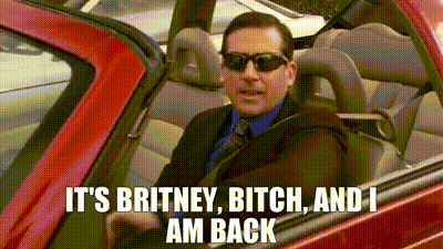 A Man In A Suit And Tie Is Driving A Red Car With The Words `` It 'S Britney Bitch And I Am Back '' GIF