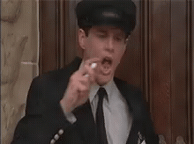 A Man In A Suit And Tie Is Eating A Candy Bar . GIF