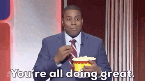 A Man In A Suit And Tie Is Eating Popcorn And Says `` You 'Re All Doing Great . '' GIF