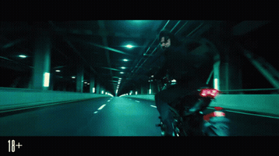 A Man In A Suit And Tie Is Fighting Another Man In A Dark Room With The Number 18+ On The Bottom Right GIF