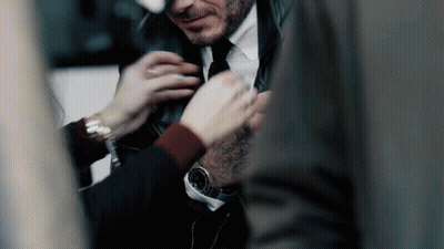 A Man In A Suit And Tie Is Getting His Tie Adjusted GIF