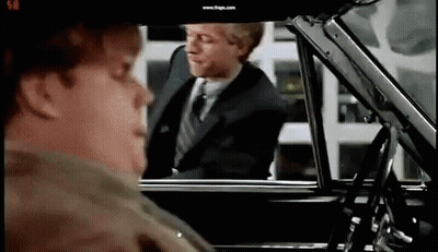 A Man In A Suit And Tie Is Getting Out Of A Car While Another Man Looks On . GIF