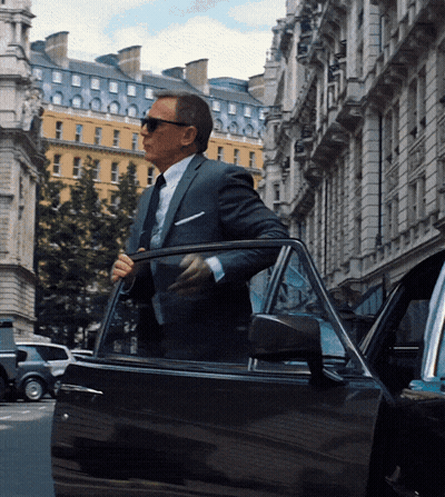 A Man In A Suit And Tie Is Getting Out Of His Car GIF