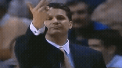 A Man In A Suit And Tie Is Giving A Middle Finger To The Camera . GIF