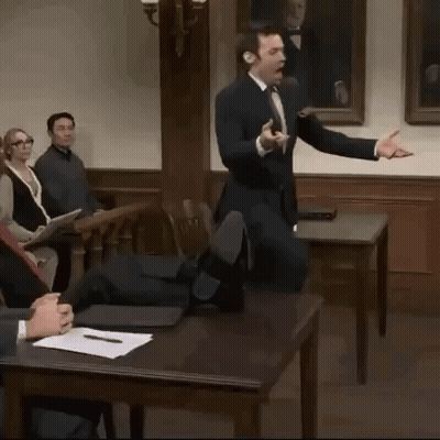 A Man In A Suit And Tie Is Giving A Presentation In Front Of A Group Of People GIF