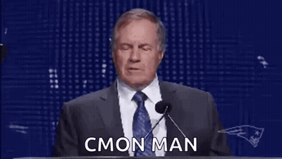 A Man In A Suit And Tie Is Giving A Speech At A Podium With Rings On His Hands . GIF