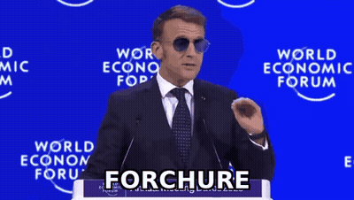 A Man In A Suit And Tie Is Giving A Speech In Front Of A World Economic Forum Sign GIF