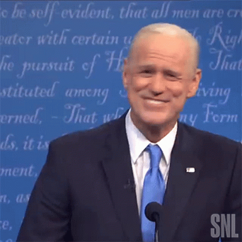 A Man In A Suit And Tie Is Giving A Speech On Snl . GIF