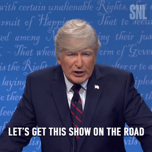 A Man In A Suit And Tie Is Giving A Speech With The Words Let 'S Get This Show On The Road Below Him GIF